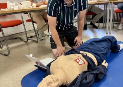 Teilnehmer des Erste-Hilfe-Kurses mit einem Dummy