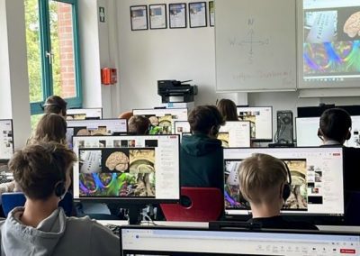 Schülerinnen und Schüler sitzen an Computern während des Workshops