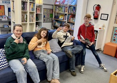 Schülerinnen und Schüler auf einem Sofa in der Stadtbücherei in Breyell